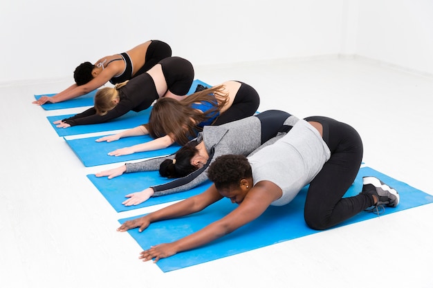 Photo gratuite femmes sur tapis faisant des étirements