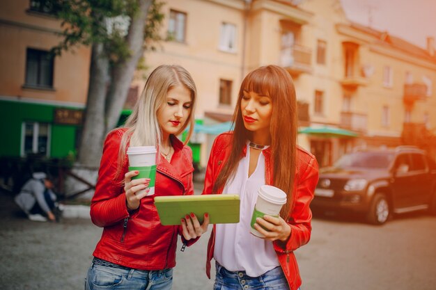 Les femmes avec des tasses à café et une tablette