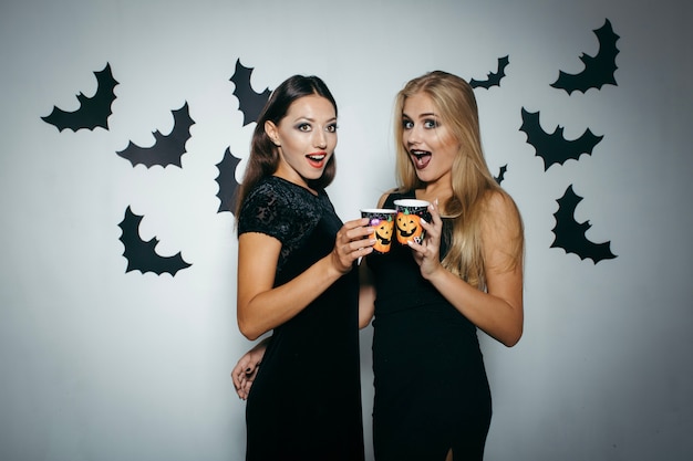 Photo gratuite femmes avec des tasses célébrant halloween