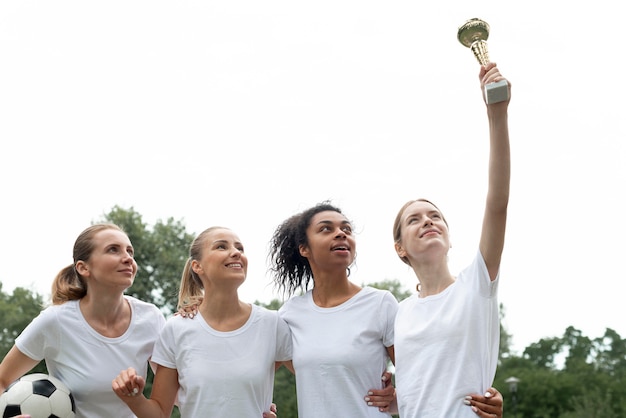 Photo gratuite femmes tenant une coupe exprimant la victoire