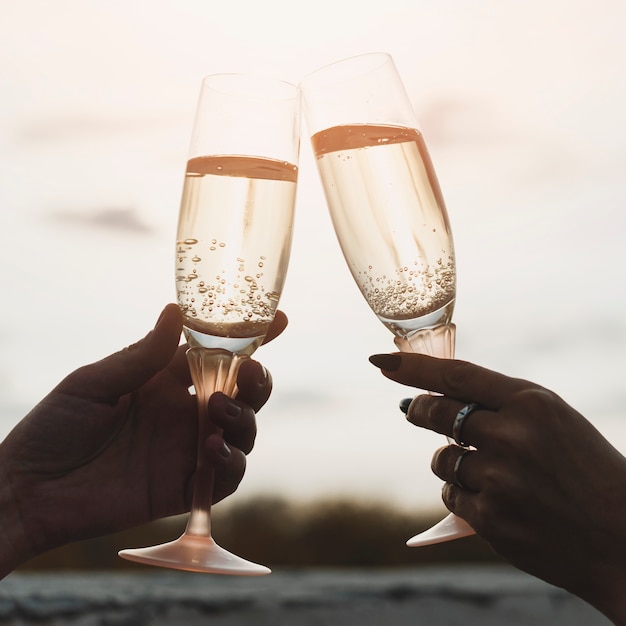 Femmes tenant des coupes à Champagne sur fond de coucher de soleil