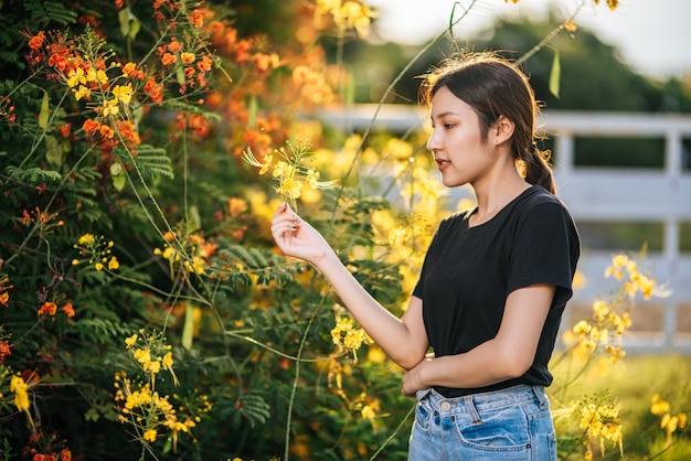 Les femmes touristes se tiennent et attrapent des fleurs dans le jardin.