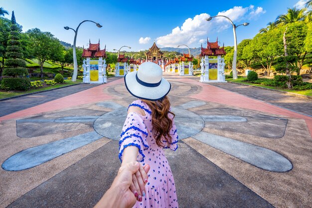 Les femmes touristes tenant la main de l'homme et le menant à Ho kham luang style thaï du nord de la Royal Flora ratchaphruek à Chiang Mai, Thaïlande.