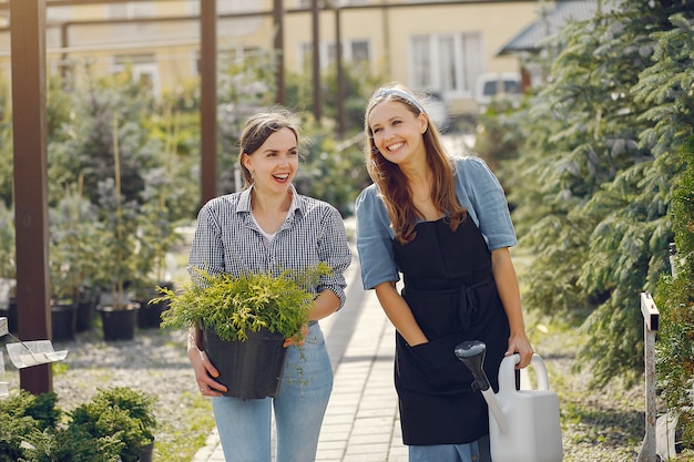 Femmes travaillant dans une serre avec des pots de fleurs