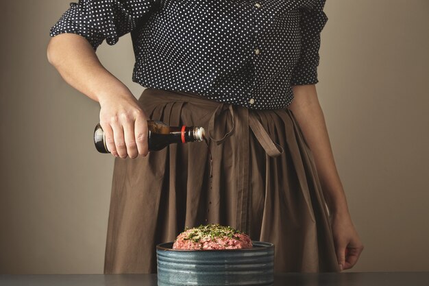 Des femmes versent de la saucisse de soja dans de la viande hachée pour cuire des boulettes ou des raviolis