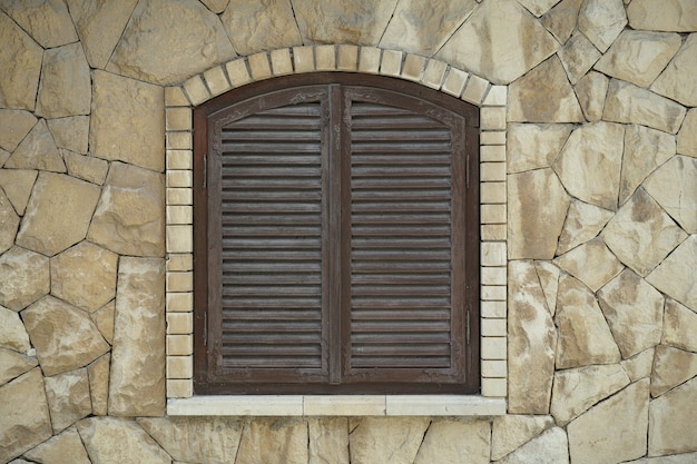 fenêtre fermée dans un mur de pierre