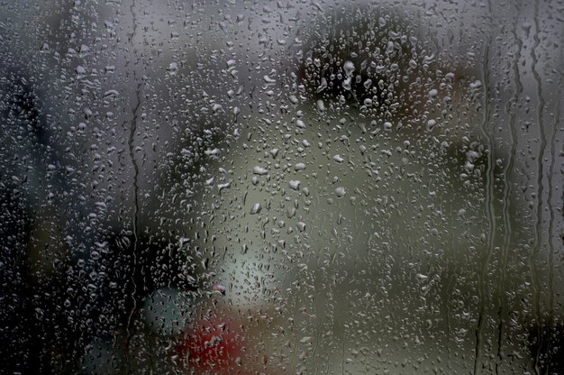 Fenêtre avec des gouttes de pluie dessus sous les lumières