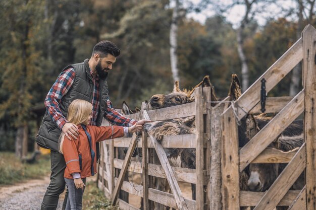 À la ferme Fermier et une fille debout près de l'enclos