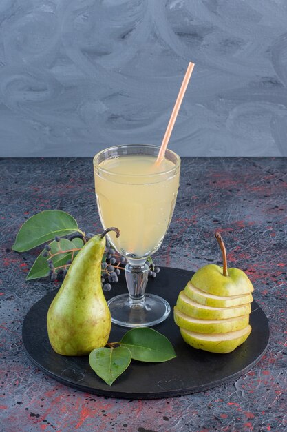 Fermer la vue du jus de poire avec des fruits frais biologiques