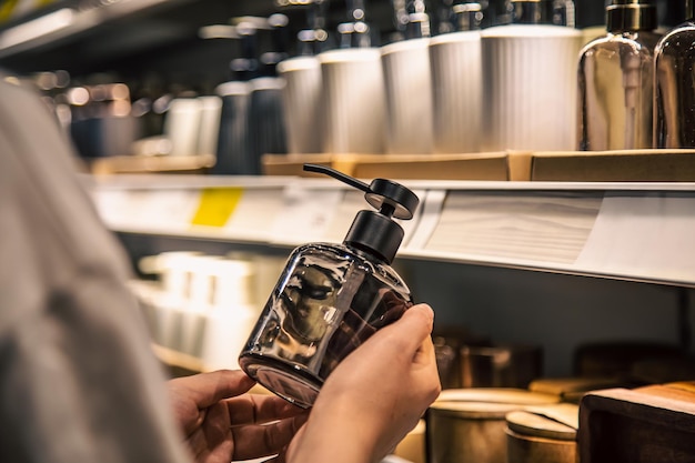 Fermez un distributeur de savon liquide dans les mains des femmes dans le magasin