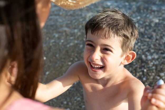 Photo gratuite fermez l'enfant et le parent au bord de la mer