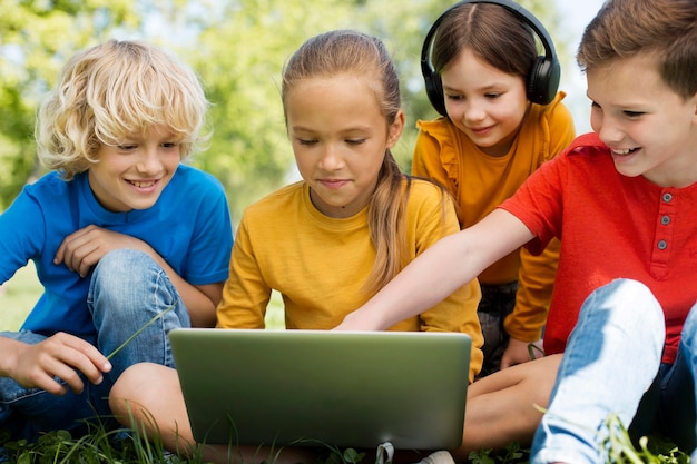 Fermez les enfants avec un ordinateur portable et des écouteurs