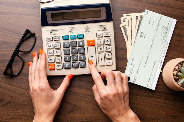 Photo gratuite fermez les mains à l'aide de la calculatrice