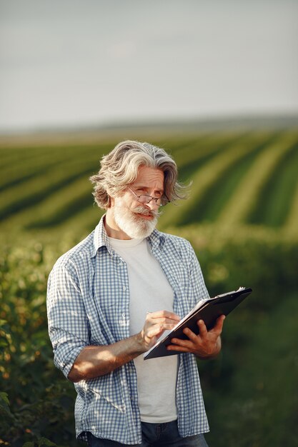 Le fermier examine le champ. L'agronome ou l'agriculteur examine la croissance du blé.