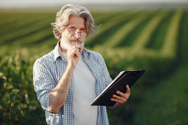 Le fermier examine le champ. L'agronome ou l'agriculteur examine la croissance du blé.