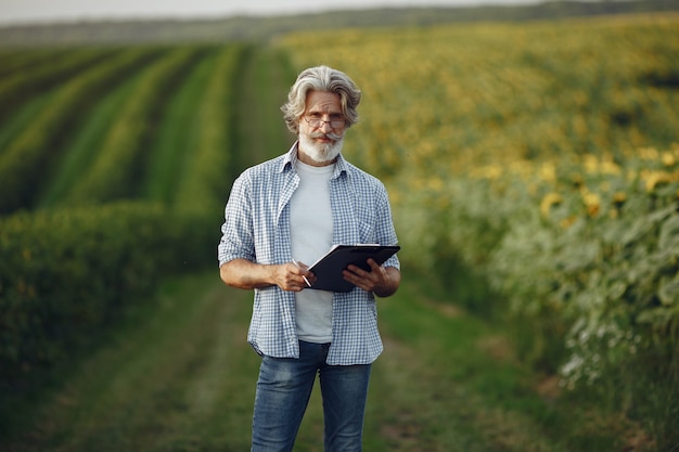 Le fermier examine le champ. L'agronome ou l'agriculteur examine la croissance du blé.