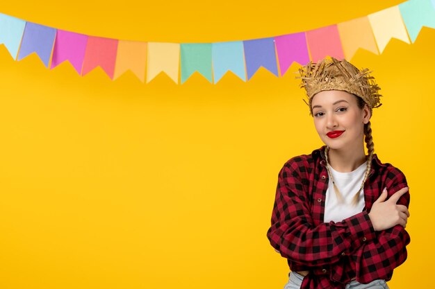 Festa junina blonde jolie fille au chapeau de paille festival brésilien avec des drapeaux embrassant les épaules