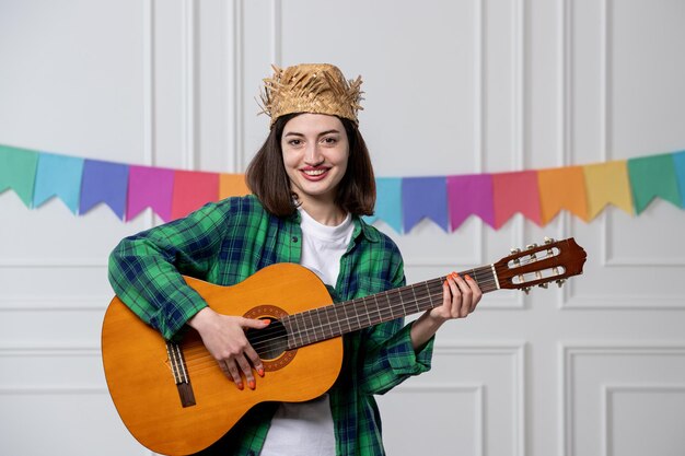 Festa junina jolie jeune fille avec chapeau de paille célébrant la fête brésilienne avec guitare