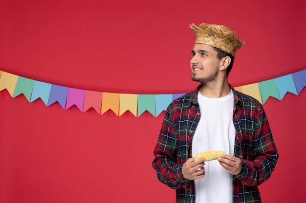 Festa junina souriant mec mignon portant un chapeau de paille célébrant le festival brésilien en levant