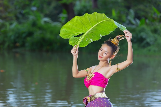 Festival Loy Krathong. Femme en tenue traditionnelle thaïlandaise tenant une feuille de bananier