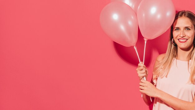 Fêtarde posant avec des ballons