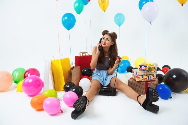 Fête d'anniversaire lumineuse. Récepteur de téléphone belle fille de mode dans les mains