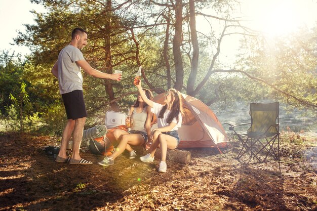 Fête, camping de groupe d'hommes et de femmes en forêt