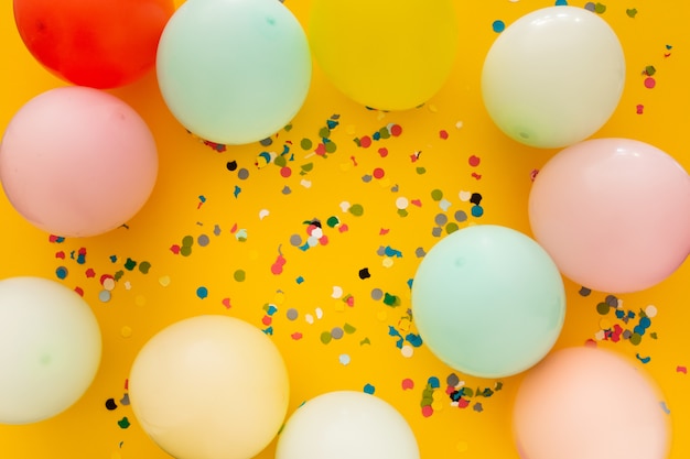 Fête avec des confettis et des ballons sur jaune