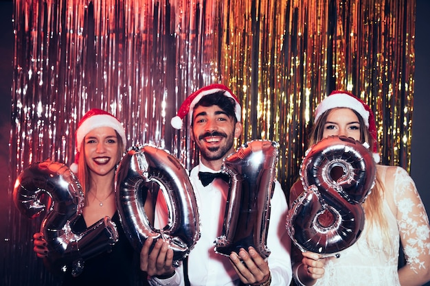 Fête du nouvel an avec des amis souriants