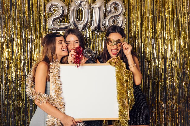 Fête du nouvel an avec des filles tenant un tableau blanc