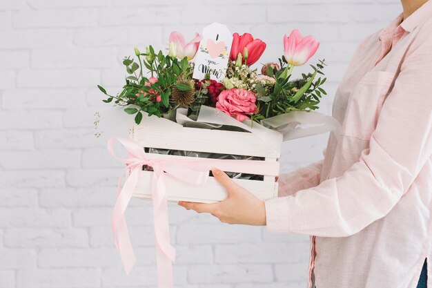 Fête des mères fond avec femme tenant la boîte à fleurs