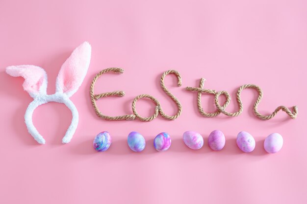 Fête de Pâques de printemps Inscription créative de Pâques sur rose avec des éléments de décoration de Pâques.