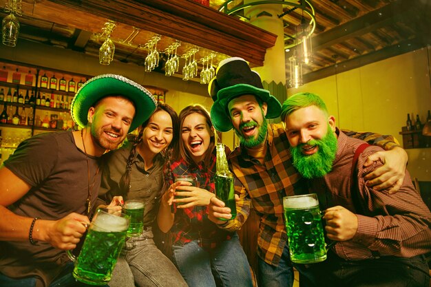 Fête de la Saint Patrick. Des amis heureux célèbrent et boivent de la bière verte.