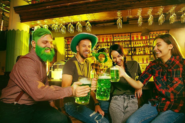 Fête de la Saint Patrick. Des amis heureux célèbrent et boivent de la bière verte.