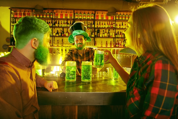 Fête de la Saint Patrick. Des amis heureux célèbrent et boivent de la bière verte.