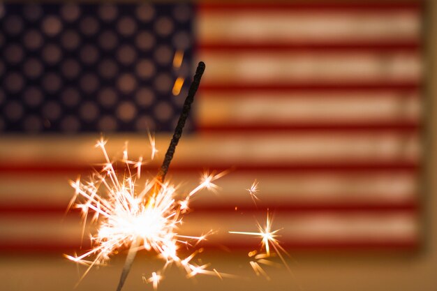 Feu de sparkler contre le drapeau américain défocalisé