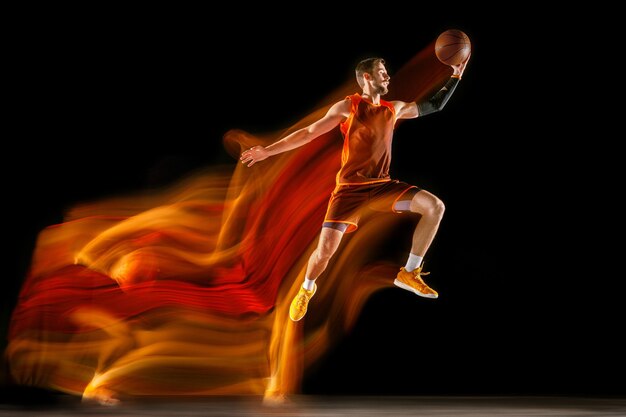 Le feu suit. Jeune joueur de basket-ball caucasien de l'équipe rouge en action