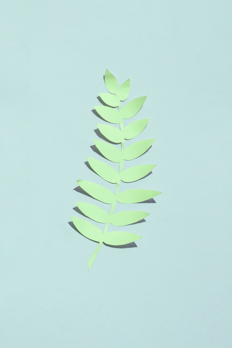 Photo gratuit feuille artificielle verte isolée sur fond bleu