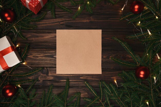 Feuille de papier et cadeau dans un cadre de couronne de noël. photo avec une place pour le texte.