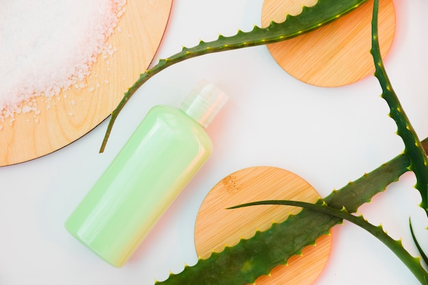 Feuilles d'aloe vera avec une bouteille de crème de beauté