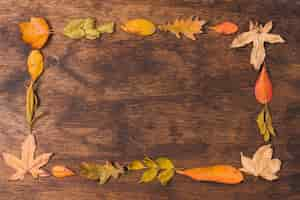 Photo gratuite feuilles d'automne cadre sur fond en bois