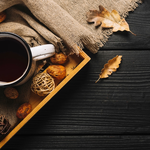 Feuilles et chiffon près du plateau avec boisson