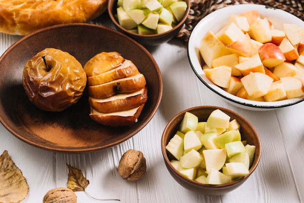 Feuilles et noix près des pommes cuites et coupées