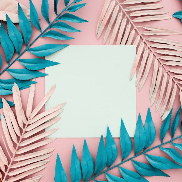 Photo gratuite feuilles de palmier tropical avec du papier blanc vierge sur fond rose