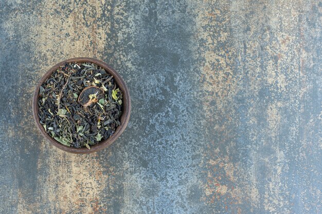 Feuilles de tisane dans un bol en bois.