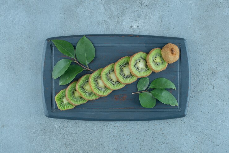 Photo gratuit feuilles et tranches de kiwi sur un plateau en bois , sur fond de marbre. photo de haute qualité