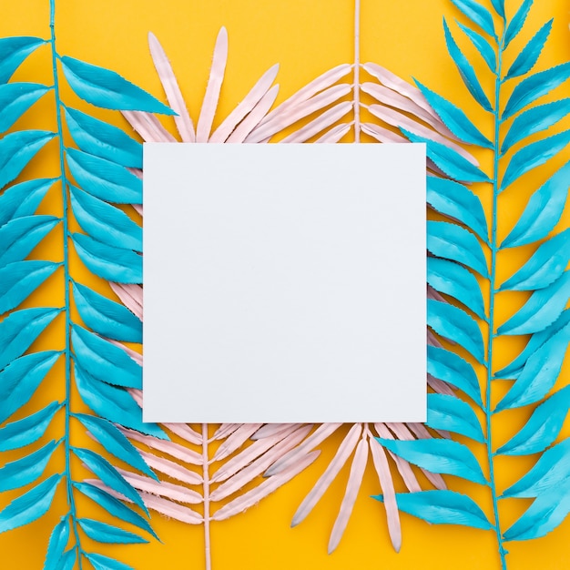 Feuilles tropicales exotiques et papier vierge sur jaune
