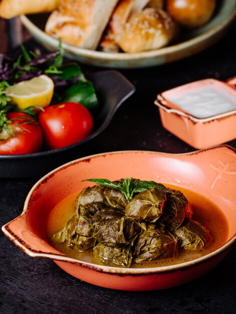 Les feuilles de vigne d’Azerbaïdjan dolma avec du yaourt à l’intérieur de la casserole rose.