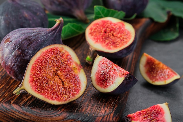 Photo gratuite figues coupées en tranches sur une planche à découper en bois mise au point sélective gros plan cadre horizontal fruits de figues mûres saisonnières régime méditerranéen idée pour la publicité