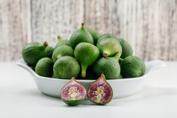 Photo gratuit figues dans une assiette avec des tranches à plat sur un mur en bois blanc et grungy